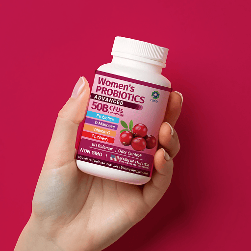A hand holding a white bottle of Women's Probiotics Advanced 50B CFUs against a vibrant magenta-pink background. The bottle features a white cap and a label with pink, purple, and blue sections, decorated with illustrations of red cranberries.